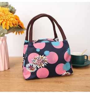Polka dot lunch bag with floral print, brown handles and secure zipper closure