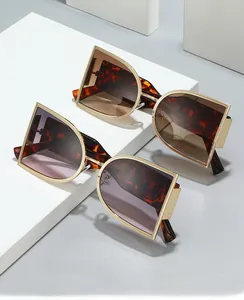 Detail of D-shaped gold metal frame sunglasses with tortoiseshell temples on display