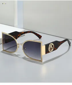 Detail of oversized sunglasses with gold wavy frame and tortoiseshell temples with S logo