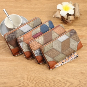 Long zip-around wallets with geometric patchwork patterns and woven wrist straps on wood