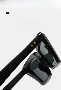 Détail de lunettes de soleil œil-de-chat noires avec rivets étoiles dorées et texture