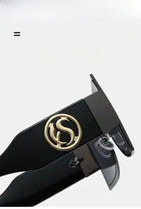Detail view of black glossy frame with gold S-logo hinge on modern sunglasses