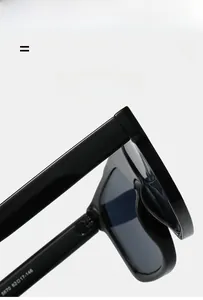 Close-up of sleek black rectangular sunglasses hinges and detailed inner frame engraving