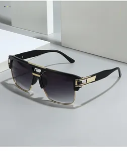 Detail of square oversized sunglasses with gold bridge and textured metal temples