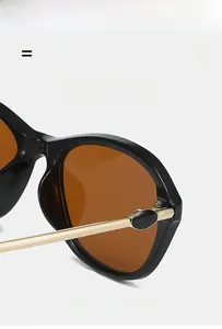 Dettaglio occhiali da sole cat-eye neri con stanghette dorate e montatura ultraleggera
