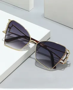 Détail de lunettes de soleil polygonales dorées avec perles et verres dégradés violets