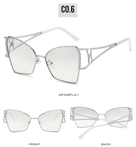Détail de lunettes de soleil œil-de-chat argentées avec strass et découpes géométriques