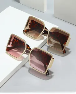 Detail of oversized square sunglasses with gold metal temples and tortoise frames