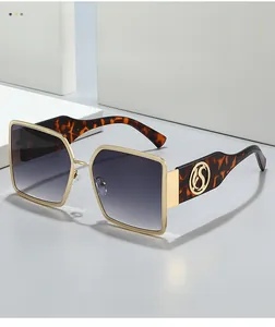 Detail of gold metal frame with textured edges and tortoise temple with S logo