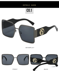 Detail view of large square sunglasses featuring a golden S-logo on black metal frames