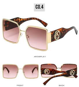Detail of oversized sunglasses showing leopard print temples and gold metal frame trim
