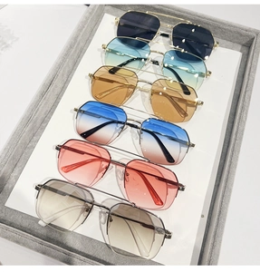 Detailed view of various metallic aviator sunglasses with gradient lenses in a display tray