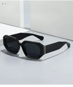 Detail of black hexagonal sunglasses featuring gold metal accents on polished temples