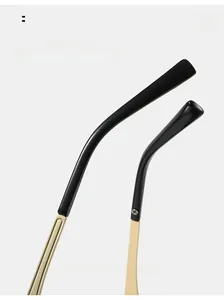 Detail of curved metal temples on oval sunglasses with black ear pads and gold finish