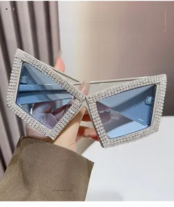 Close-up of oversized square sunglasses with sparkling rhinestone-encrusted frame edges