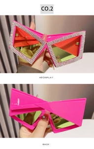 Macro view of pink rhinestone-encrusted butterfly sunglasses with orange lenses