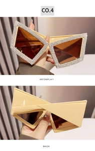 Close-up of butterfly sunglasses with rhinestones on beige frames and brown lenses