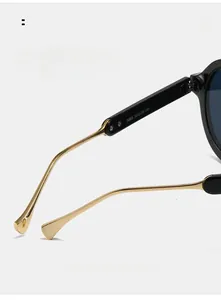 Dettaglio macro delle stanghette in metallo dorato con curve antiscivolo per occhiali da sole