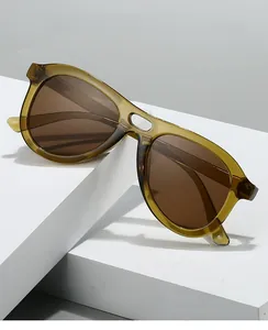 Detail of oversized double-bridge sunglasses with amber frames and tinted lenses