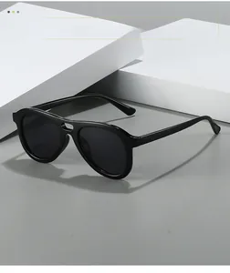 Close-up of stylish black double-bridge aviator sunglasses on a geometric block