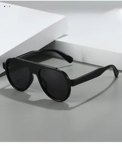 Close-up of classic black aviator sunglasses with wide frames on a white pedestal