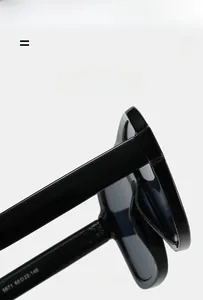 Detail view of square oversized sunglasses showing temple hinges and frame texture