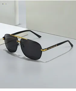 Détail de lunettes aviateur polarisées avec accents dorés et texte BE POPULAR