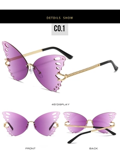 Macro detail of rimless butterfly sunglasses with purple gradient lenses and chain gold temples