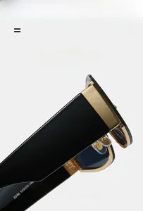 Close-up of stylish black sunglasses showing thick temples and gold metal accents