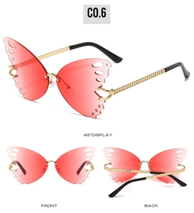 Detail view of butterfly rimless sunglasses with pink gradient lenses and golden chain arms