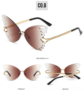 Detailed close-up of butterfly-shaped rimless sunglasses with gold chain temples and brown lenses