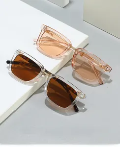 Detail of square sunglasses with transparent pink frames and golden metal bridge
