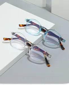 Detail of retro small frame glasses in transparent blue and clear with tortoiseshell temples