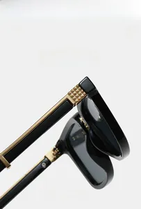 Detail of square vintage sunglasses with gold hinges and texture material