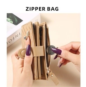 Detail showing hands placing coins into the zipper pocket of a khaki quilted wallet