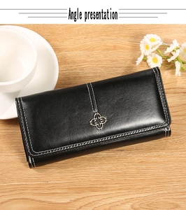 Vue détaillée du portefeuille vintage noir avec surpiqûres blanches et boucle trèfle