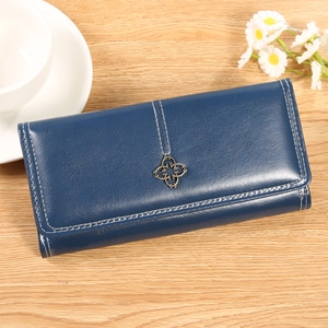 Détail du portefeuille en cuir bleu foncé avec surpiqûres et fermoir fleur en métal