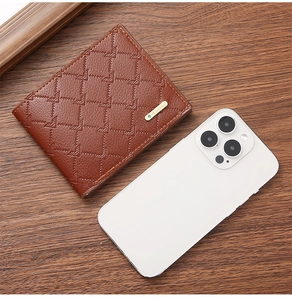 Short brown PU leather men's wallet next to a phone for size comparison and detail