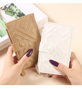 Close-up of quilted card wallet in khaki and white featuring button and zipper detail