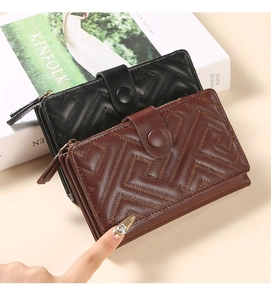 Detail view of black and brown leather wallets with geometric embroidered stitching texture