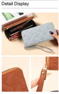 Close-up of heart embroidery on woven leather wallet with smooth metal zipper detail