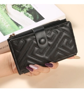 Detail of black medium wallet with geometric quilting and gold zipper held by a model