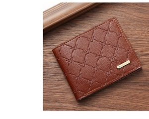 Macro view of brown PU leather men's bifold wallet with quilted eagle pattern and metal logo