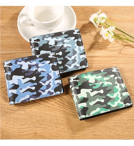 Three camouflage print men's bifold wallets in navy, grey, and green on a wooden surface