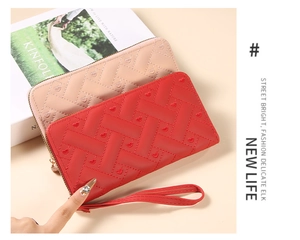 Detail of red and pink long wallets with woven texture and heart embroidery
