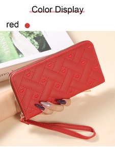 Detail of red PU leather wallet featuring heart embroidery and gold metal zipper closure