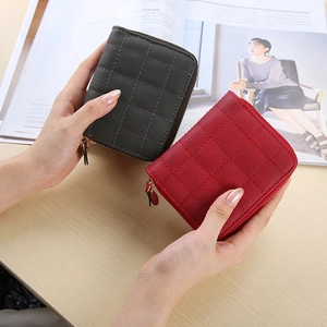 Close-up of mini quilted zipper wallets in grey and red with professional stitching