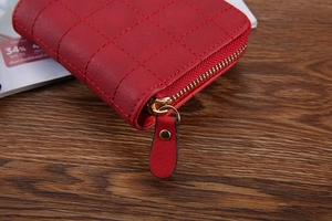 Close-up of red quilted coin purse featuring golden zipper and premium leather texture
