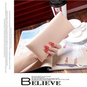 Detailed view of pink lychee texture leather long wallet held in a lifestyle setting