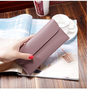 Detailed view of elegant dark purple long wallet with lychee pattern on a wooden desk